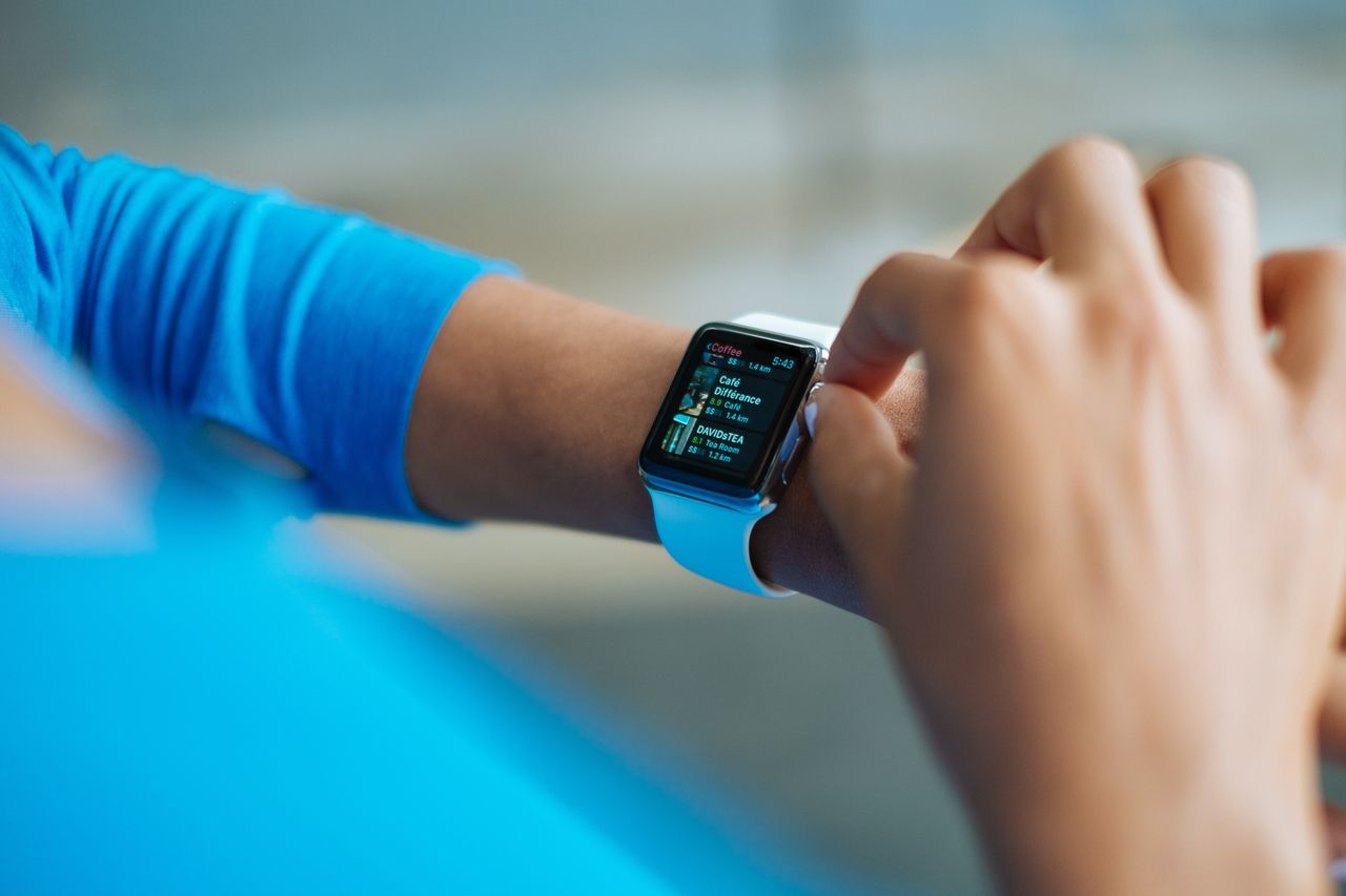 gallery-2 Person interacting with a smartwatch, showing a fitness application on the screen.