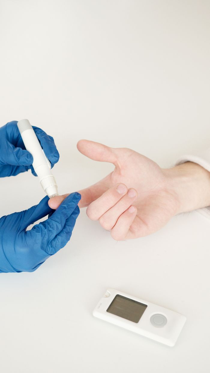 why-choose-us A healthcare professional tests blood sugar with a glucometer and lancet pen in a medical setting.