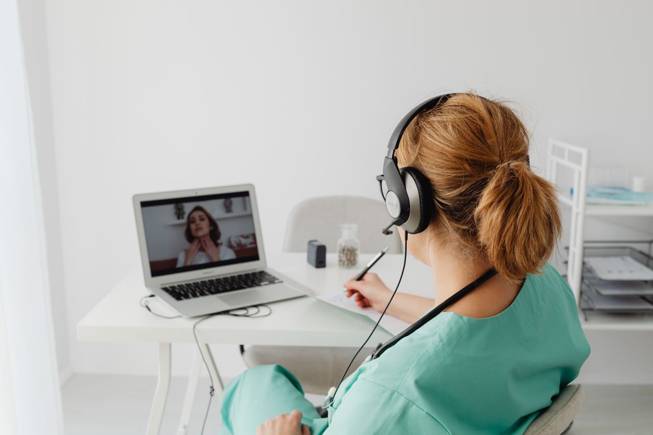 about-01 A female doctor conducts a virtual patient consultation via video call, showcasing telemedicine technology.